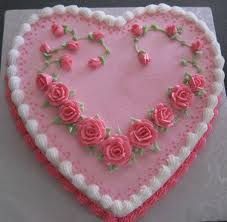 a heart shaped cake with pink roses on it