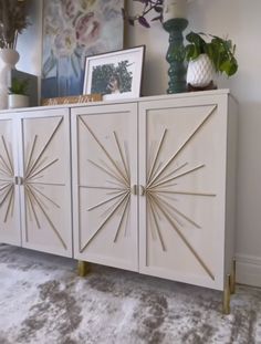 a white sideboard with gold starburst handles and brass legs in a living room