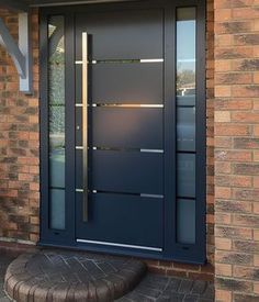 a blue front door on a brick house with glass panels and sidelights, next to a stone step