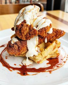 fried chicken and waffles on a plate with sauce drizzled over them