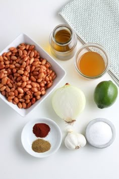 the ingredients to make this dish include beans, onions, and limes on a white surface