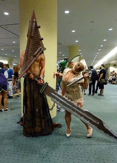 two people dressed up in costumes holding swords and standing next to each other on the floor