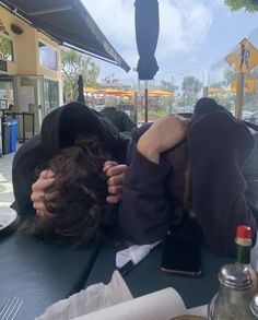 a person laying on top of a table with an umbrella over their head