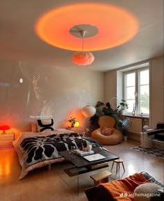 a bedroom with a bed, desk and chair in it's center area is lit up by orange lights