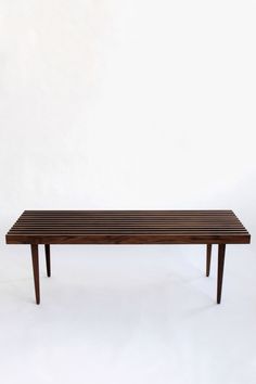 a wooden bench sitting on top of a white floor