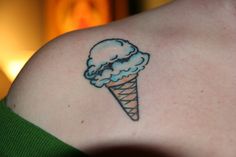 an ice cream cone tattoo on the back of a woman's shoulder