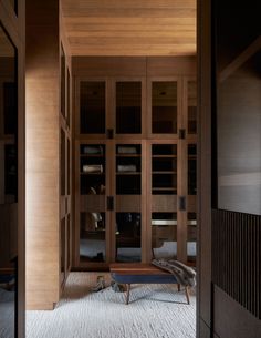 a room with wooden shelves and white carpeted flooring in front of an open door