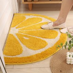 a woman standing on top of a yellow and white rug next to a potted plant