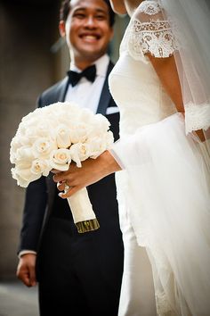 the bride and groom are standing together outside