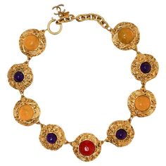 Condition : very good Made in France Materials : gold plated metal, resin Colors : yellow, amethyst, ruby Measurements : length: 39 cm + 5 cm of adjustable chain, size of a coin medallion : 3 x 3 cm Gold finish metal Stamp : yes Year : 1990-1992 Details : A succession of inlaid pieces in gilded metal with a resin stone at the center of each one. Snap hook closure. Flexibility of 8 cm to adjust the chain length. A CC charm at the end of the chain. No visible sign of wear. Comes in its original bo Resin Colors, Ivory Necklace, 1980s Jewelry, Vintage Chanel Bag, Vintage Choker Necklace, Chanel Suit, Resin Stone, Vintage Choker, Chocker Necklace