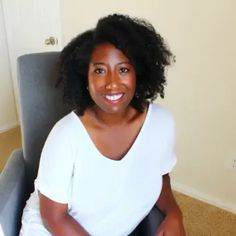 a woman sitting in a chair smiling at the camera