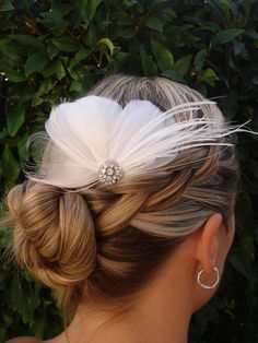 a woman with blonde hair wearing a white feather headpiece