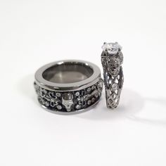 two wedding rings with diamonds on them sitting next to each other in front of a white background