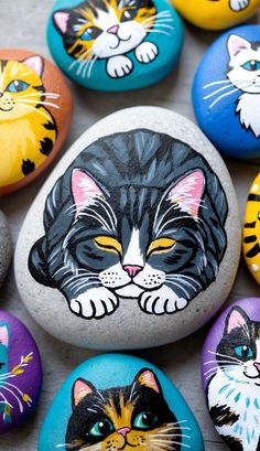 several painted rocks with cats on them