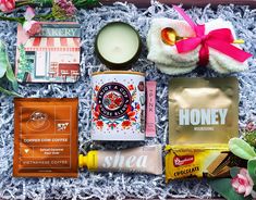 the contents of a gift box are laid out on carpeted area with flowers and candles