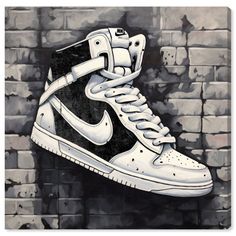 a painting of a white and black nike shoe on a brick wall in front of a brick wall