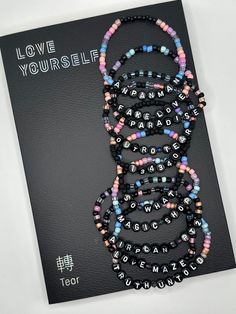 Love Yourself Tear BTS album beaded bracelet. Each bracelet features a song title from the album with color and design inspired by the album cover  Please keep in mind that colors may appear different due to individual screen settings. Bts Friendship Bracelet, Bts Beaded Bracelet, Bts Bracelets, Bts Accessories, Bts Tickets, Bts Diy, Bts Bracelet, Kandi Bracelets, Diy Bracelet Designs