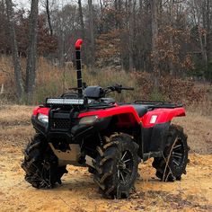 a red four - wheeler is parked in the dirt