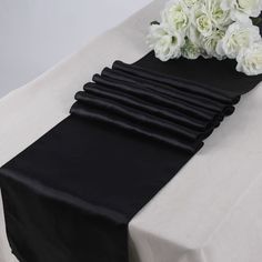 black table runner with white flowers on it