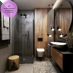 a modern bathroom with wood paneling and glass shower stall, toilet, sink, mirror