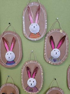 some bunny ears are hanging from the side of a green table cloth covered wall ornament