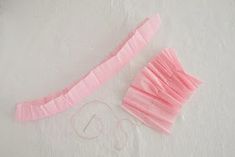 a pair of pink garters sitting on top of a white table next to yarn