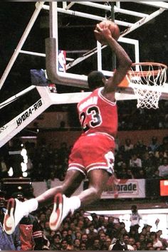 a basketball player dunking the ball in front of an arena full of people watching