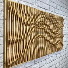 a wooden wall hanging on the side of a white brick building with wavy lines carved into it