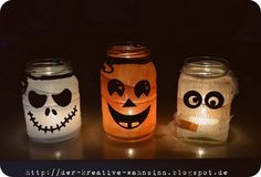 three mason jars decorated to look like jack - o - lanterns