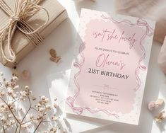 a pink birthday card on top of a table next to some flowers and presents,