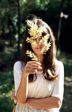 a woman holding a plant in her hands