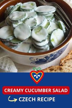 a bowl filled with cucumber salad on top of a table next to bread