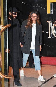 a man and woman are holding hands as they walk through an elevator