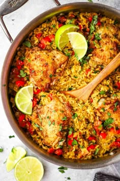 chicken and rice dish in a pan with lime wedges on the side, ready to be eaten