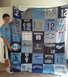 a young boy is holding up a blanket made out of sports jerseys and numbers on it