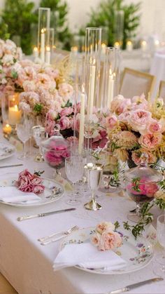 a long table is set with flowers and candles for an elegant wedding reception or special event