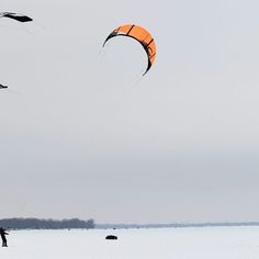 two people are flying kites in the snow