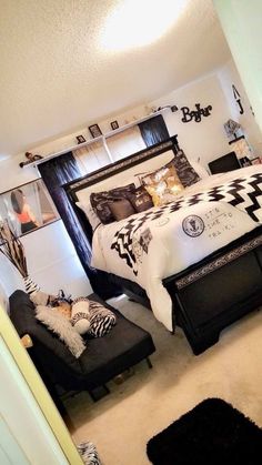 a bedroom with black and white bedding, zebra print pillows, and pictures on the wall