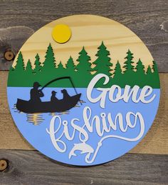 a wooden sign that says gone fishing with two people on a boat in the water