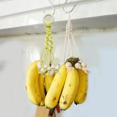 three bunches of bananas hanging from hooks