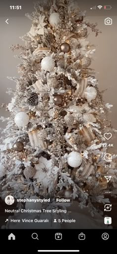 a white christmas tree with gold and silver ornaments