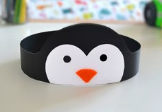 a black and white penguin headband sitting on top of a table