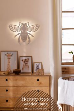 a wooden dresser topped with pictures next to a wall mounted animal sculpture and framed photos