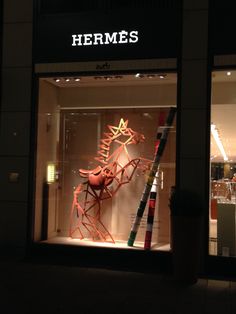 a store front window with an orange sculpture in it's display case at night