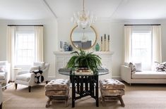 a living room filled with furniture and a table in front of a mirror on the wall