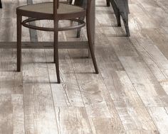 an image of a dining room with wood flooring on the walls and wooden chairs