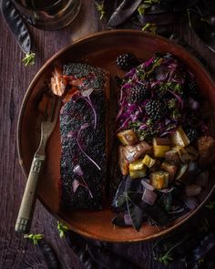 a plate with fish, potatoes and vegetables on it next to a knife and fork