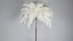 a floor lamp with white feathers on it