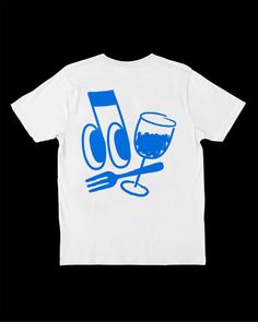 a white t - shirt with blue graphic on the front, and a glass of wine next to it