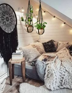 an attic bedroom decorated in white and black with hanging planters on the wall above the bed